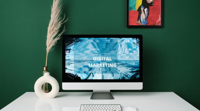 Moderniame biure dirbantis rinkodaros specialistas analizuojantis skaitmeninės reklamos grafikus kompiuterio ekrane.