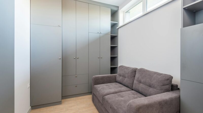 Jauki ir funkcionali svetainė su minkšta sofa-lova, moderniais baldais, lentynomis daiktams bei šiltu apšvietimu, sukurta ribotoje erdvėje.